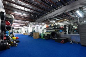 A well-equipped gym with blue carpeting, designed for fitness activities and workouts.