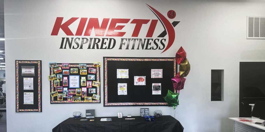 A front desk of the gym featuring a wall for events, happenings on a calendar, and other announcements, as well as how to contact us.